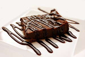 A brownie with chocolate syrup drizzled over it