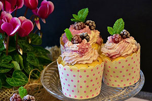 Three cupcakes with frosting and berries
